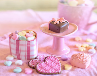 brownie encima de um prato em formato de corações com doces ao lado